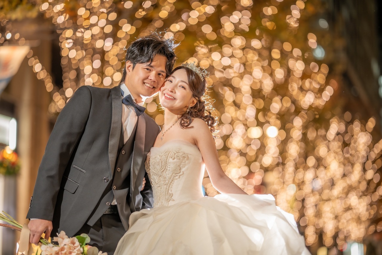 丸の内イルミネーションの玉ボケを背景に笑顔を見せる新郎新婦のウェディングフォト
