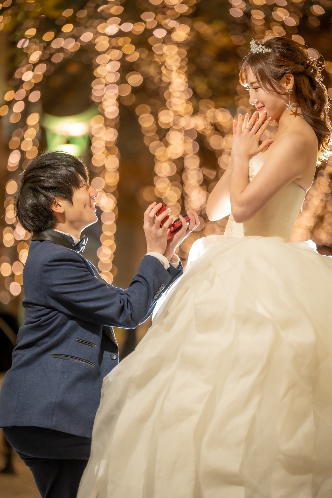 丸の内イルミネーションの中でCartierのリングケースを手にプロポーズする新郎と新婦