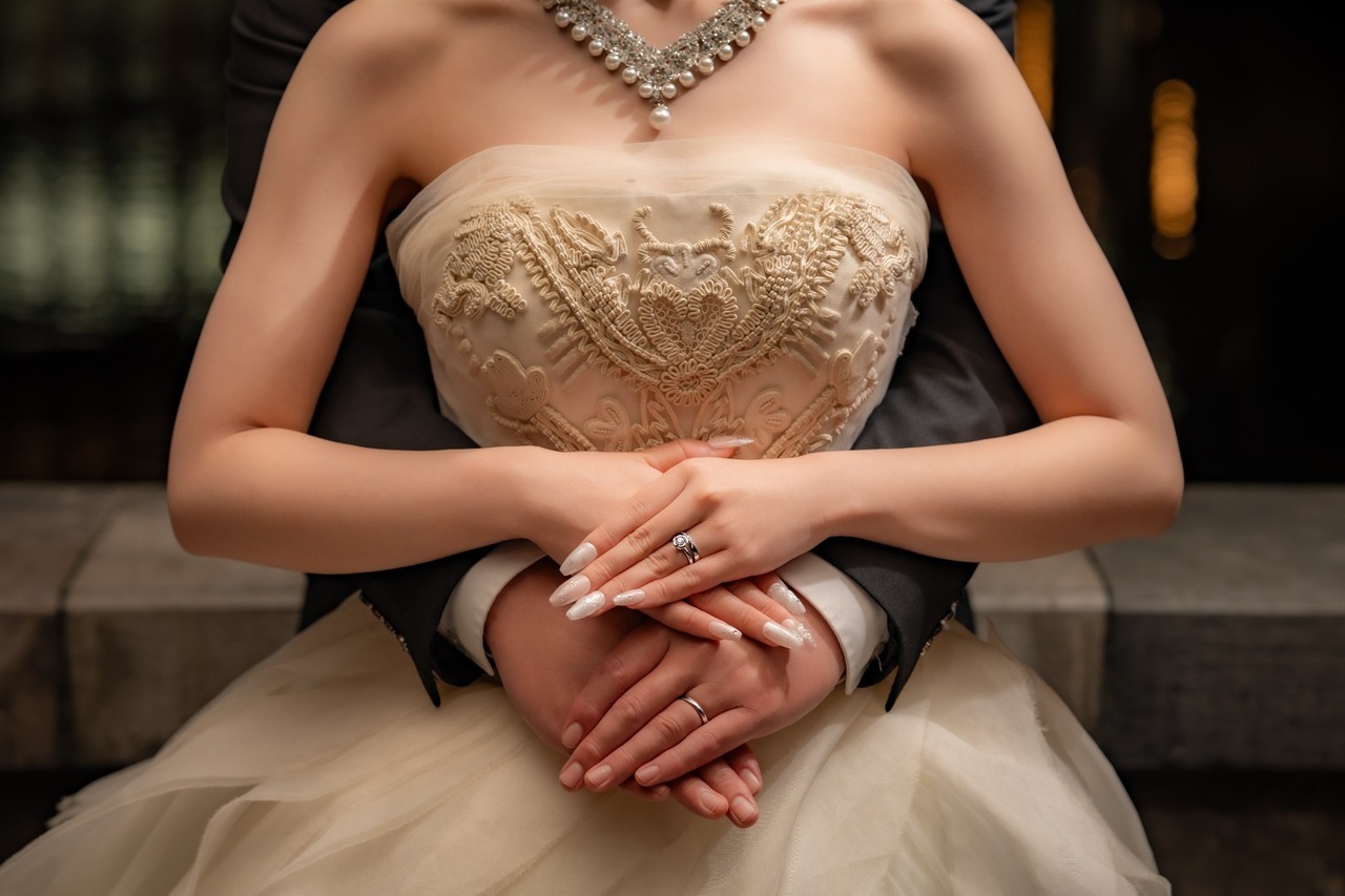 結婚指輪を着けた新郎新婦が手を重ねる東京駅ウェディングフォトの手元カット