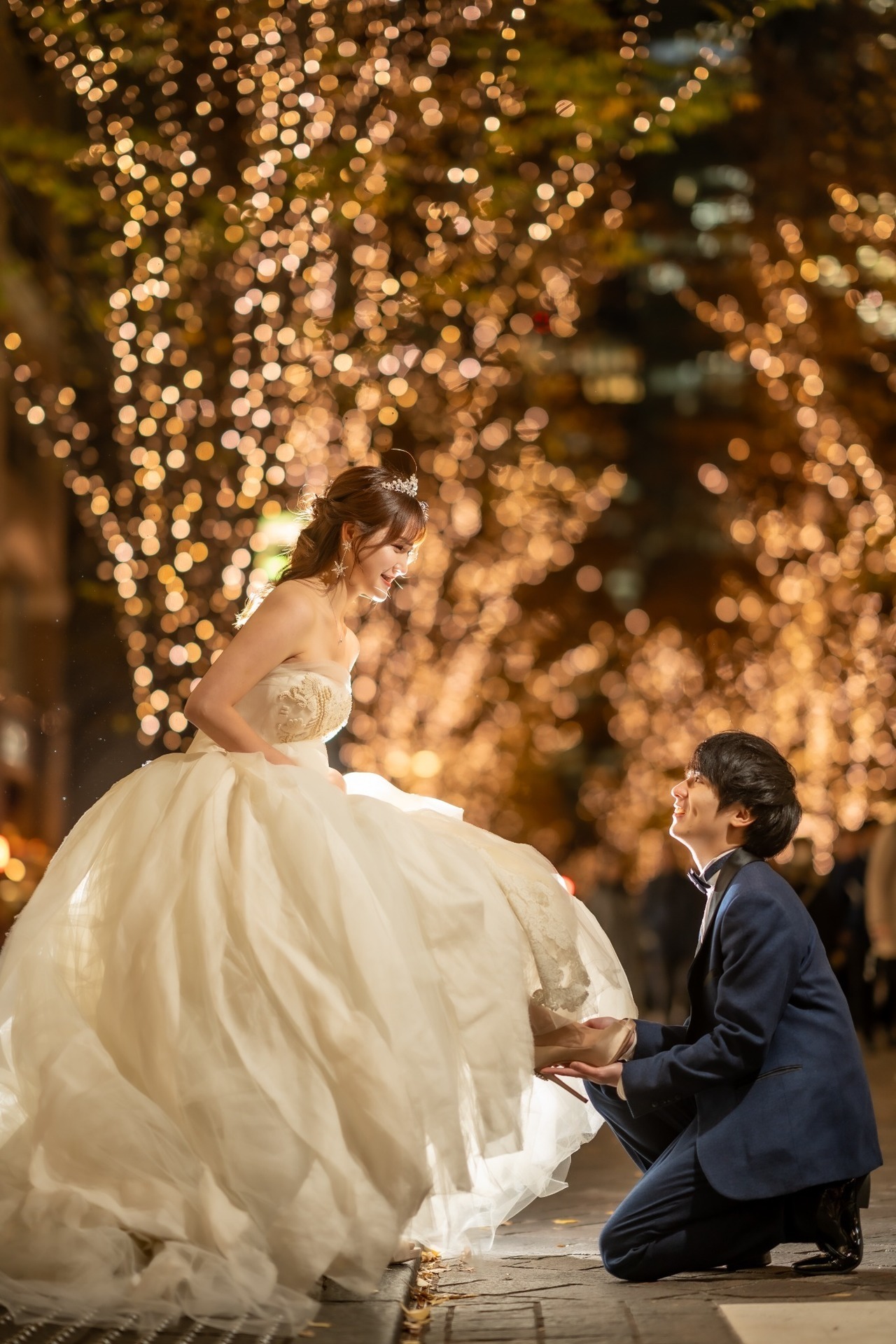丸の内イルミネーションを背景にプロポーズシーンを撮影する新郎新婦のウェディング前撮り