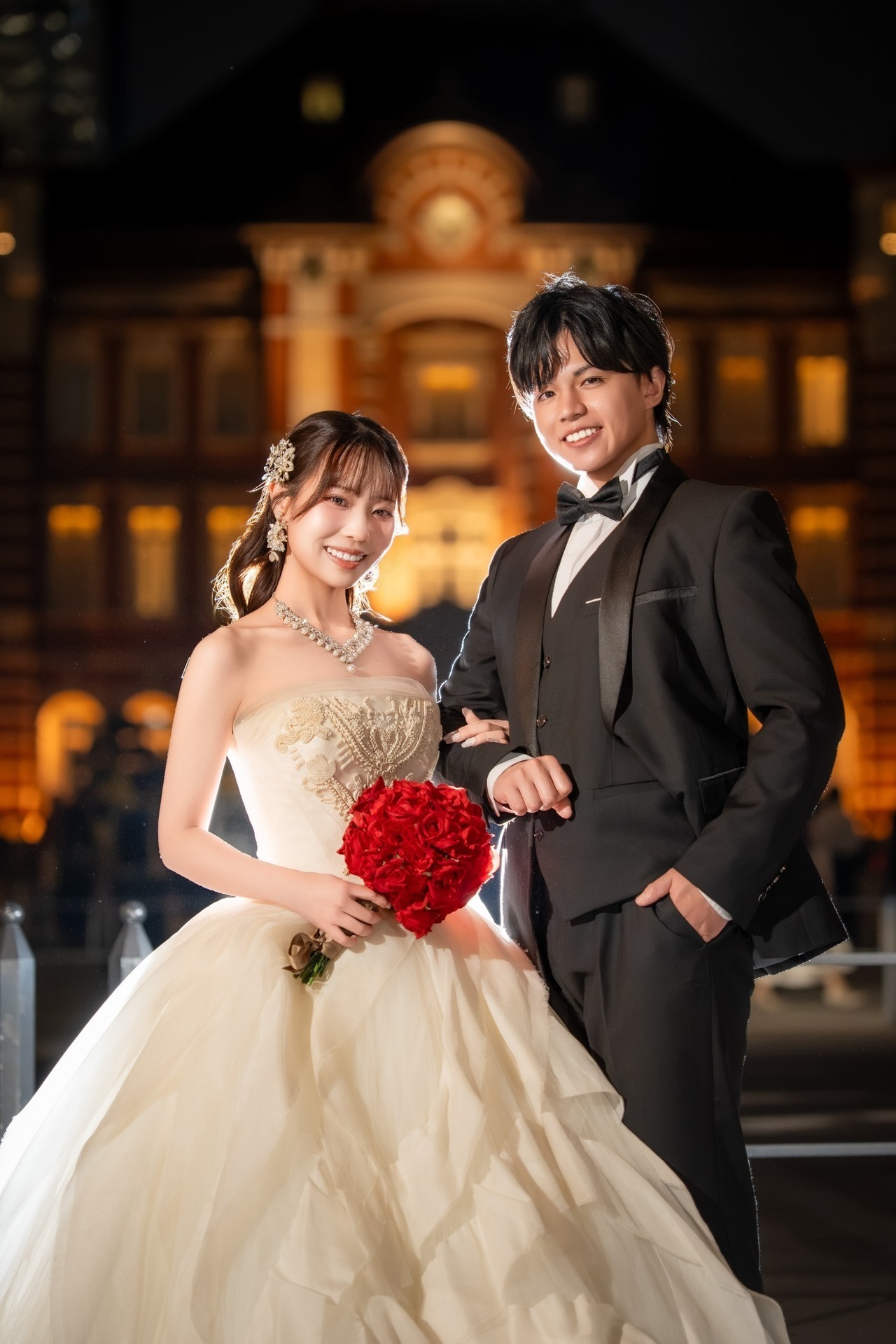夜の東京駅丸の内駅舎を背景に並ぶ新郎新婦のウェディング前撮り