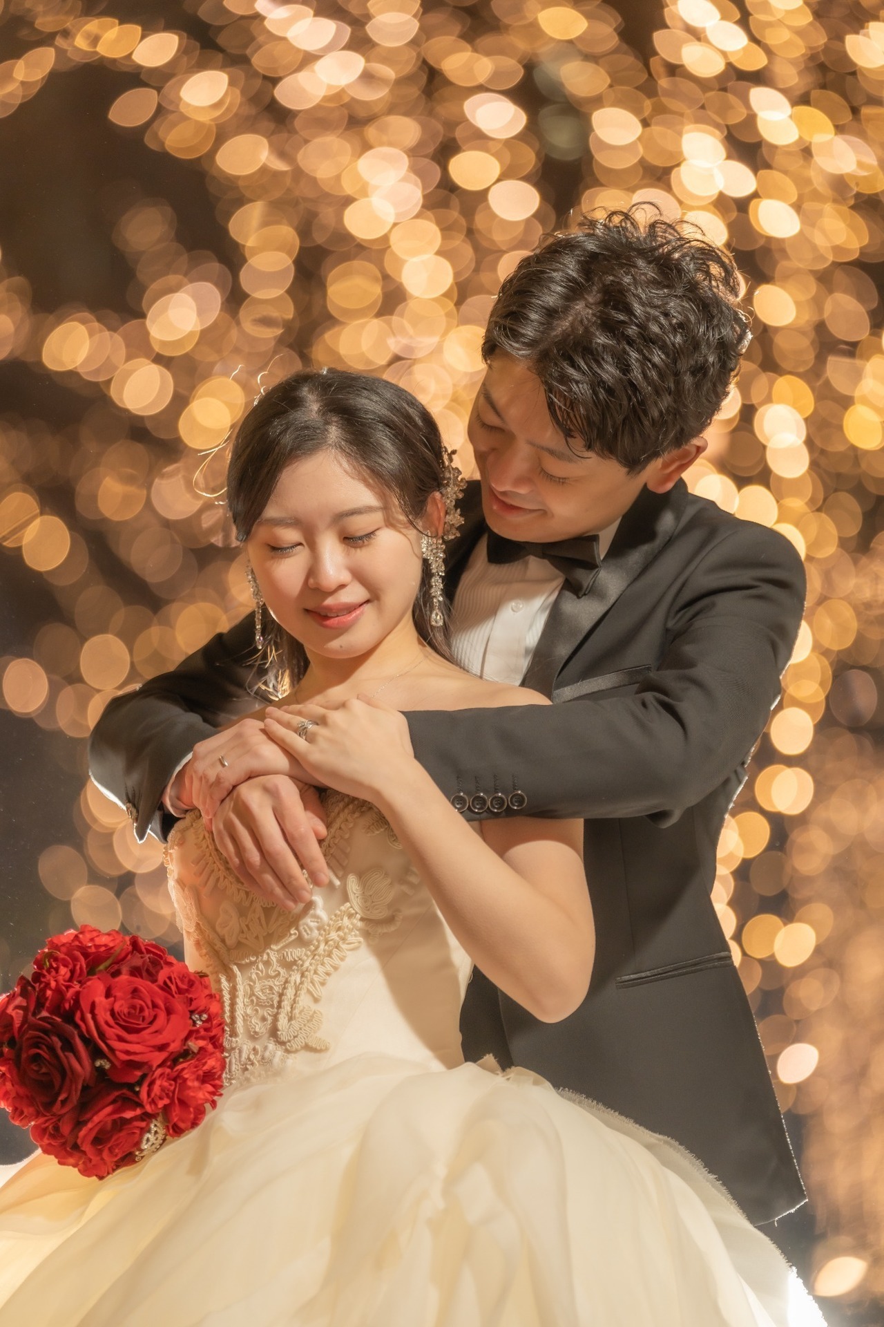 丸の内イルミネーションの玉ボケを背景に寄り添う新郎新婦の前撮り写真